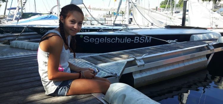 Segelschule BSM Jugendlicher entspannt am Hafen